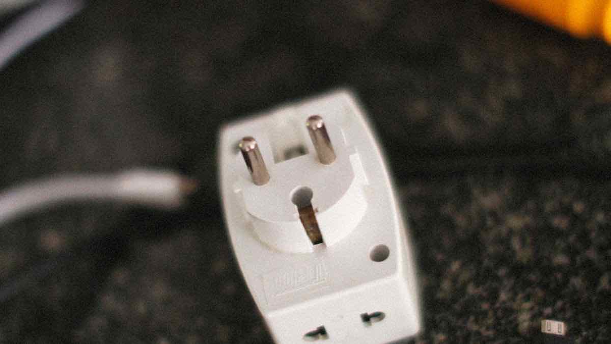 A universal travel plug adapter on a dark surface, a metaphor for a compatibility shim that lets old code plug into a new API