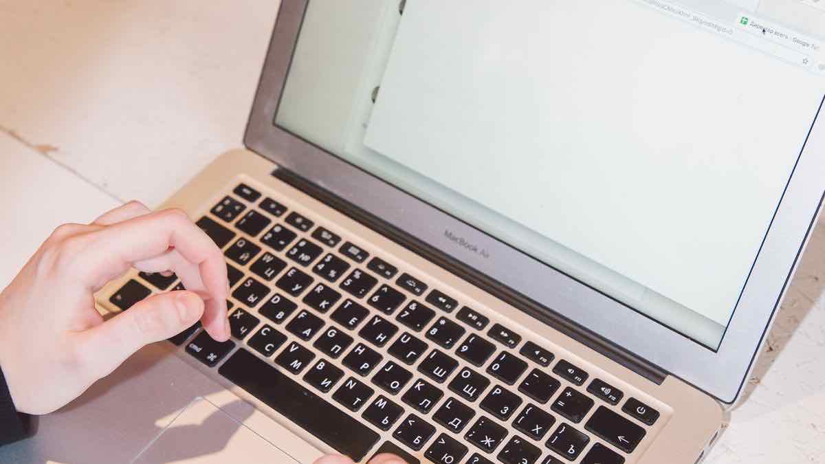 A person reviewing a lead list on a laptop in an office, the outreach step after the pipeline produces verified emails