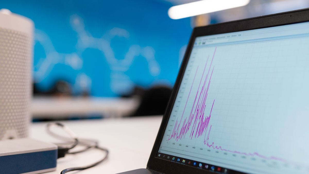 A rising bar chart on a laptop screen showing month-over-month growth data