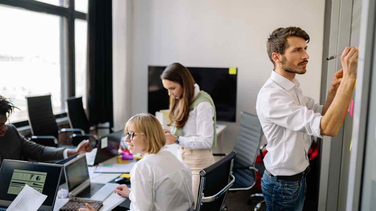 A team of colleagues collaborating in a modern office, representing a growing company's headcount