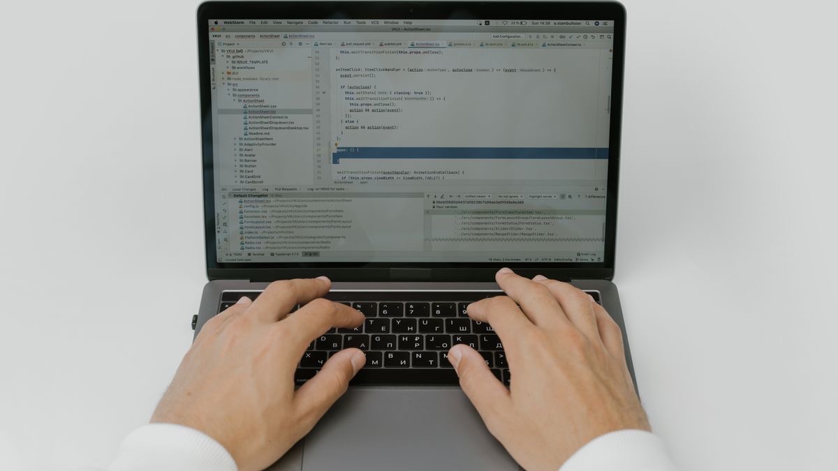 Hands typing filtering code into an IDE on a laptop