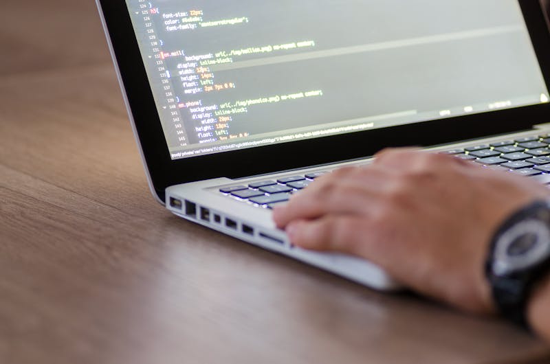 Developer writing image search API code on MacBook