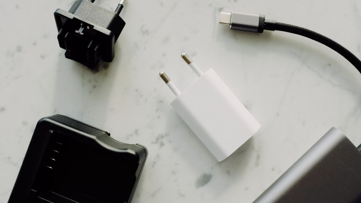Assorted power adapters and a USB-C cable laid out on a marble surface
