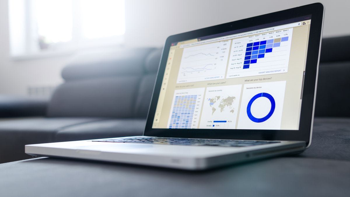 A laptop showing an analytics dashboard with charts and world-map data, the blended many-users view Search Console reports
