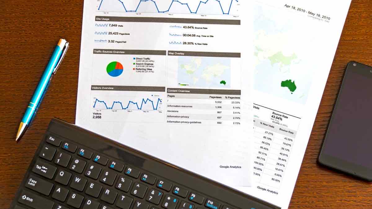 A printed analytics report with charts beside a keyboard and pen, auditing request logs against billing