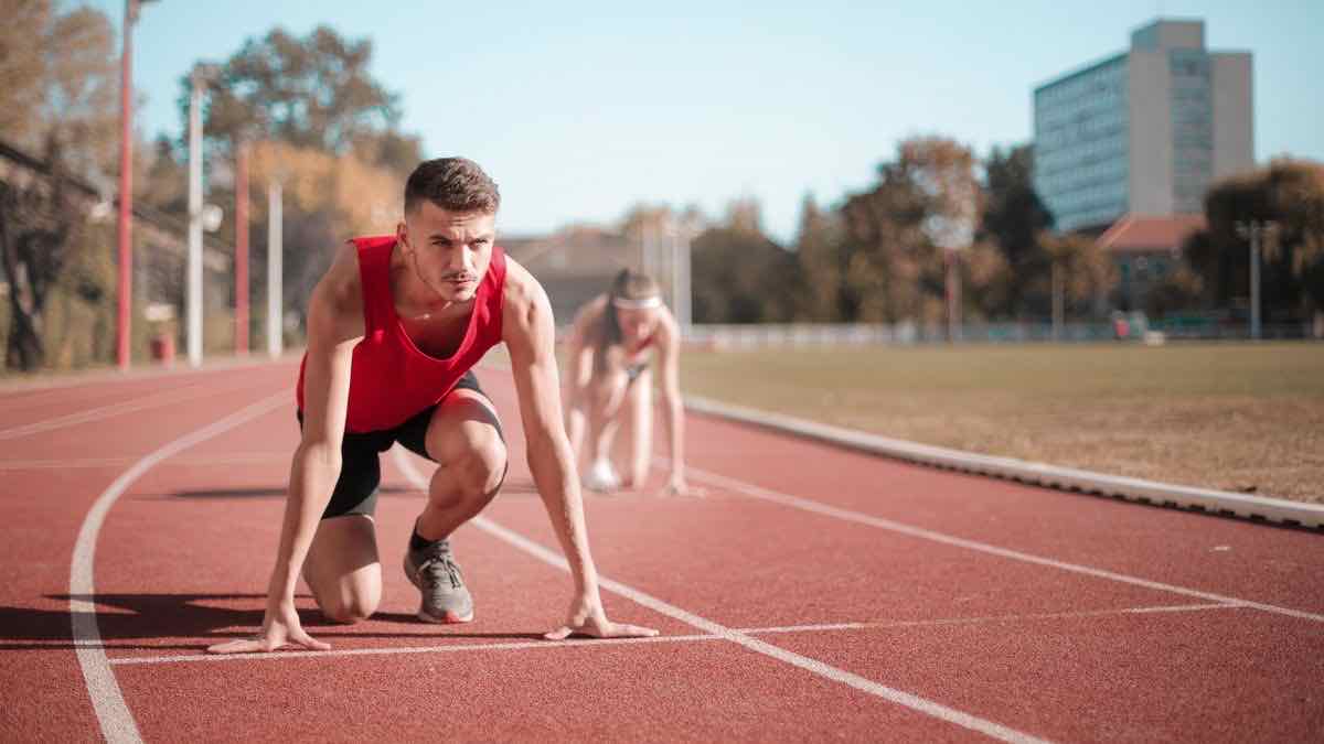 A sprinter in set position on a running track, representing getting started fast with Go
