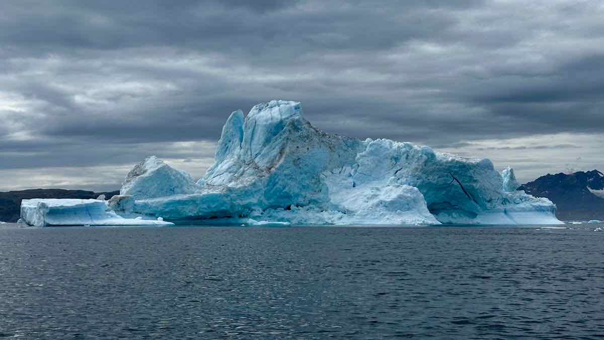 An iceberg mostly hidden underwater, representing SERP API hidden costs below the visible price