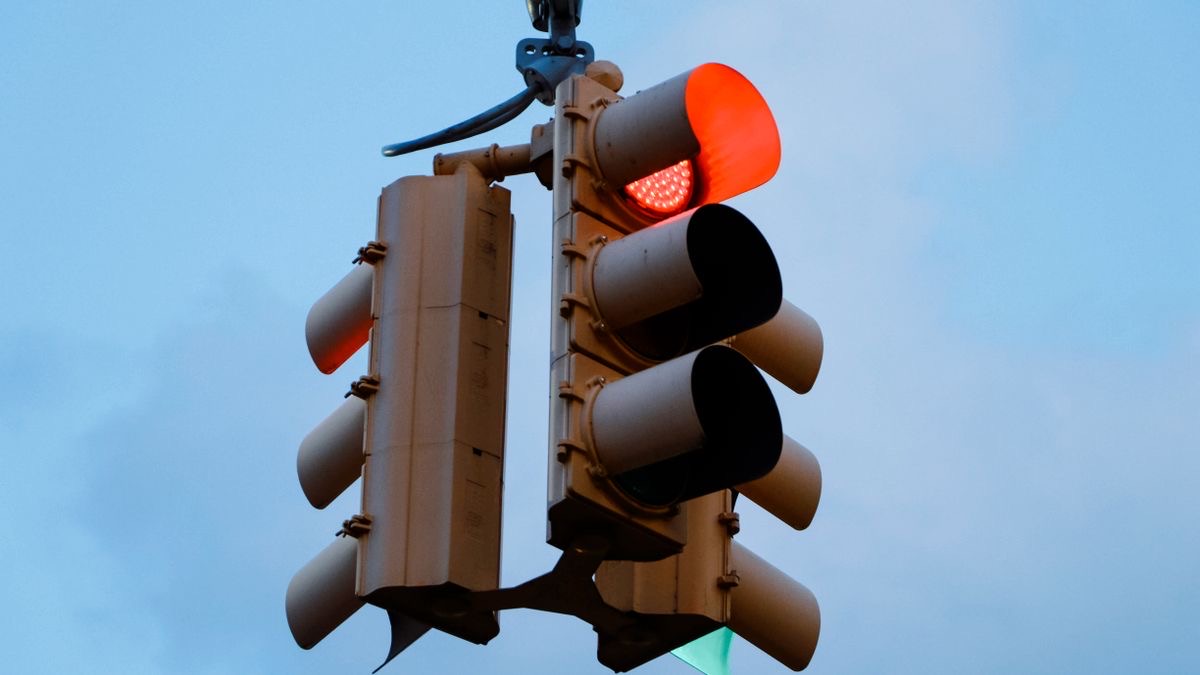 A red traffic light against the sky, representing SERP API rate limits stopping requests