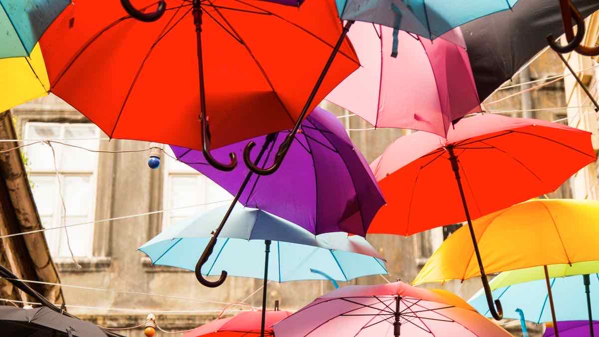 Dozens of colorful umbrellas hanging over a street, each one different, representing personalized search results