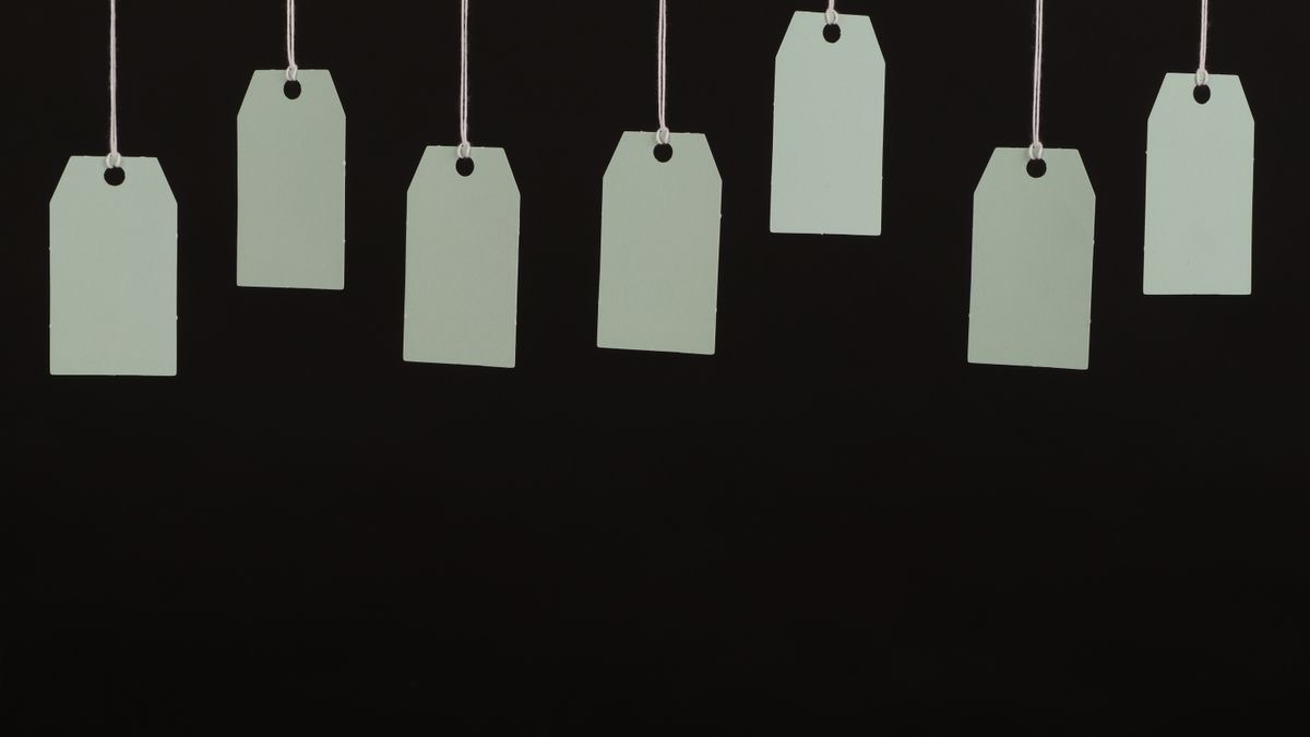 A row of price tags of different sizes hanging on strings, illustrating identical products advertised in incompatible units